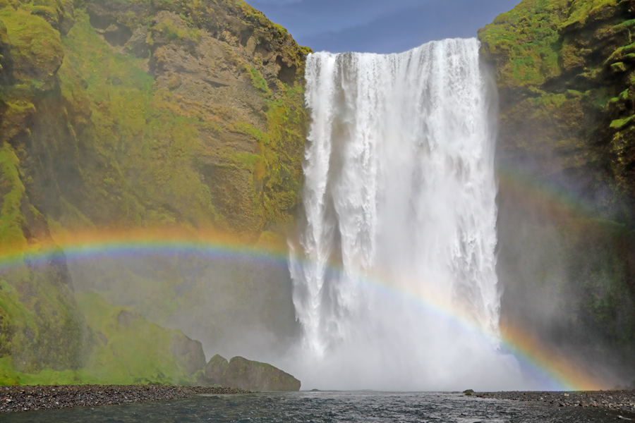 Bei direkter Bestrahlung mit Sonnenschein bildet sich am Skogafoss ein intensiver Regenbogen.